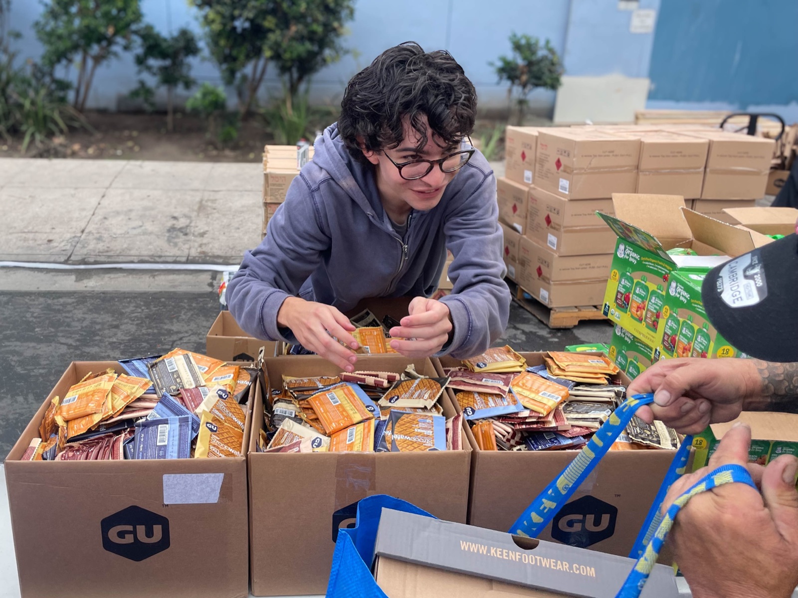 A volunteer sorting GU energy snacks into boxes