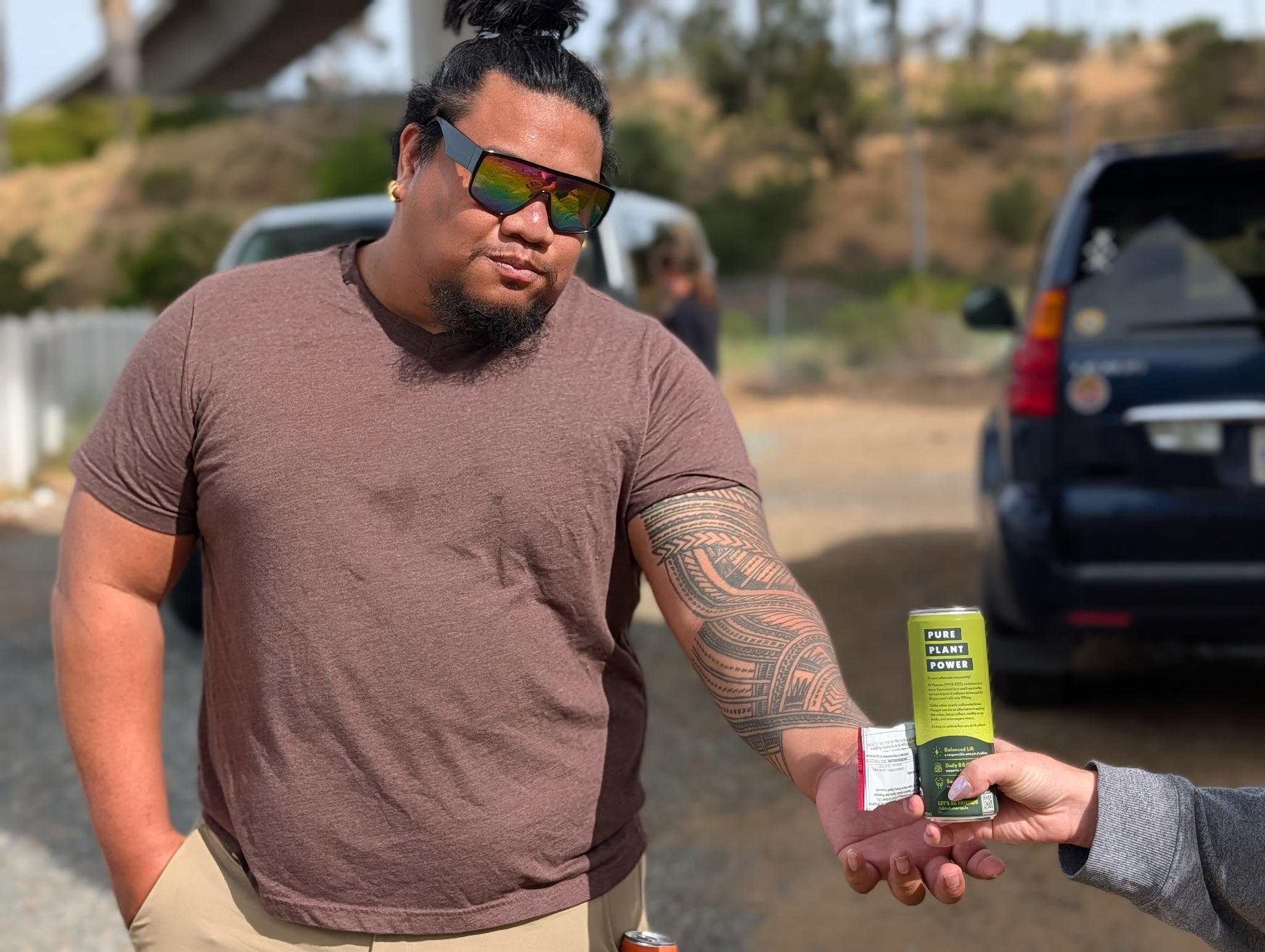Teen Health volunteer handing a beverage to a young man during distribution