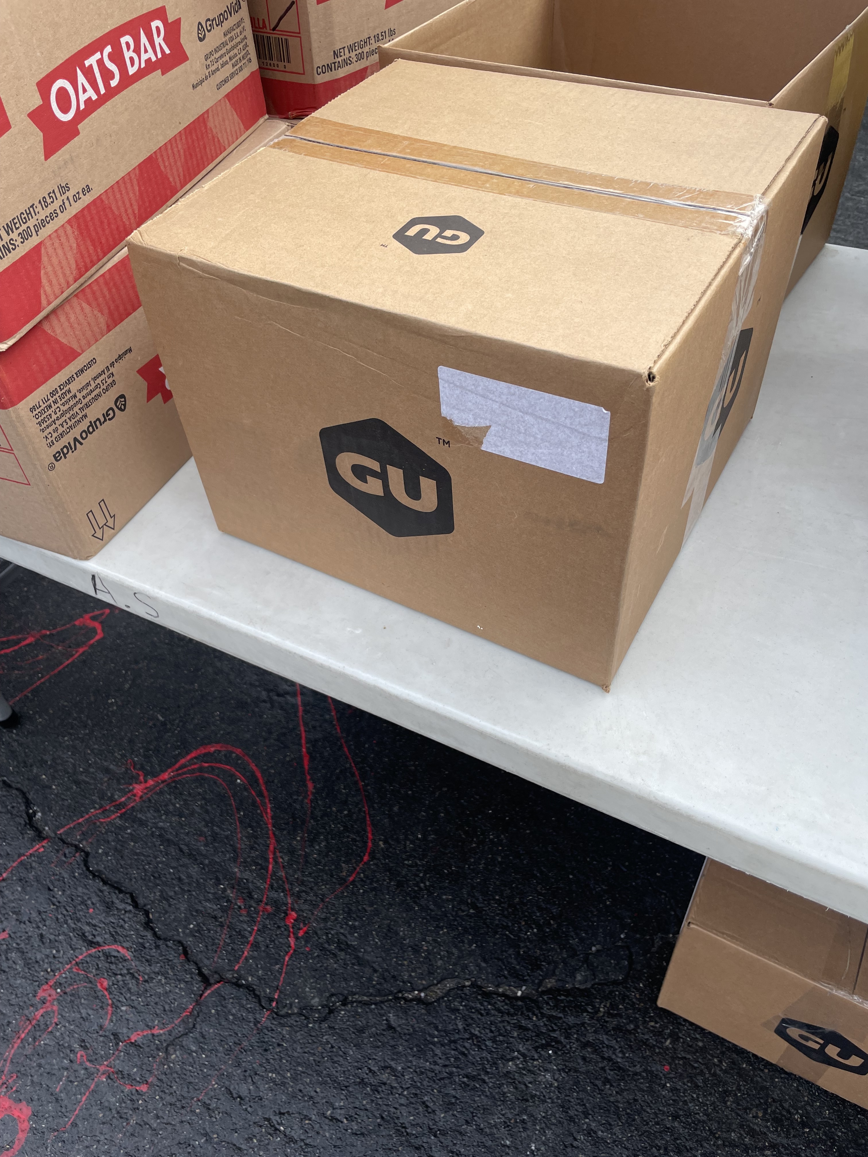 GU energy boxes staged for distribution alongside other partner products